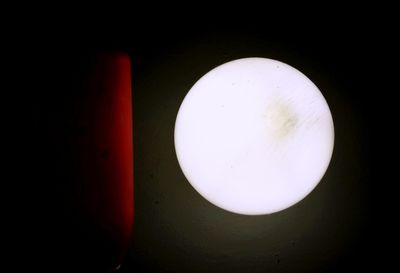 Close-up of illuminated light bulb against black background