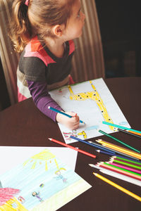 High angle view of girl drawing at table