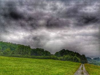 Scenic view of field against cloudy sky