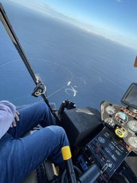 Low section of man standing on boat in sea