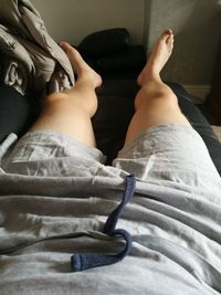 Low section of woman sitting on bed