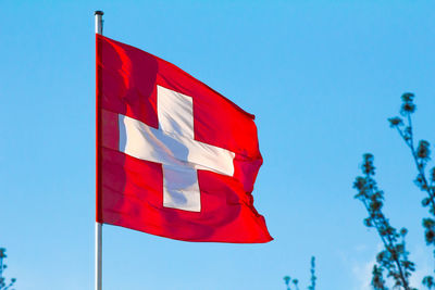 Low angle view of flag against blue sky