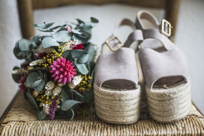 Close-up of flowers and shoes on table