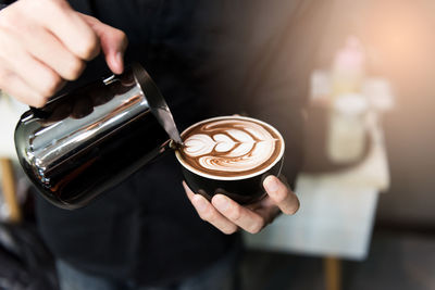 Cropped image of hand holding coffee cup