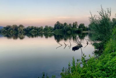 Scenic view of lake against sky at sunset