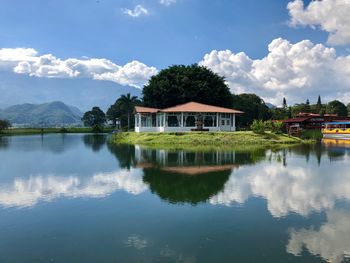 Building by lake against sky