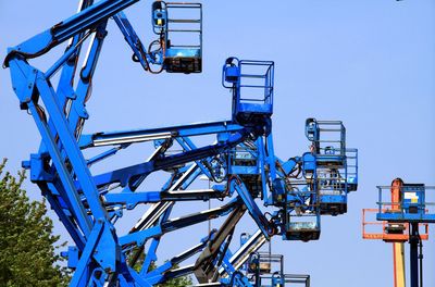 Low angle view of ferris wheel against clear blue sky