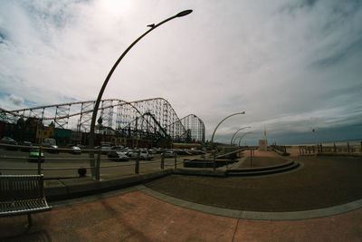 View of amusement park by sea against sky