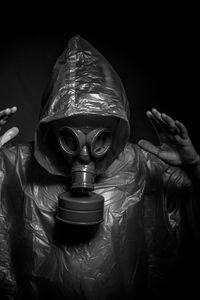 Man wearing gas mask against black background