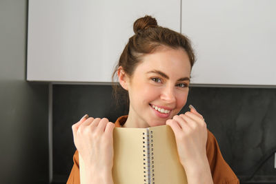 Portrait of young woman sitting at home