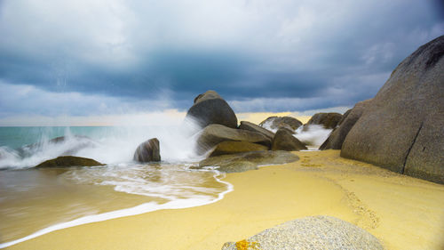 Scenic view of rocks on beach against sky