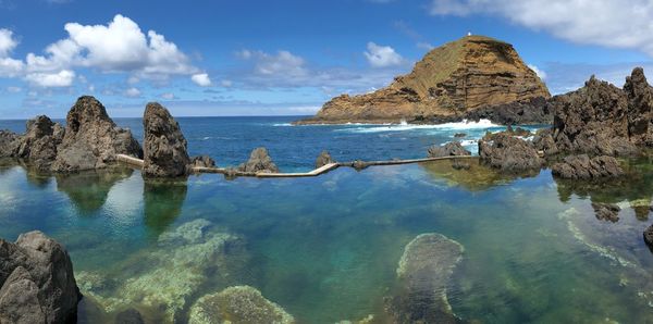 Panoramic view of rocks in sea against sky