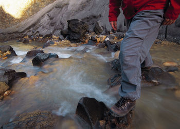 Partial view of woman crossing stream in landmannalauga