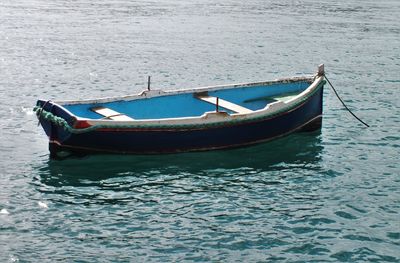 Boat moored in river on sunny day