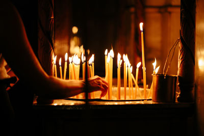 Person by illuminated candles in temple