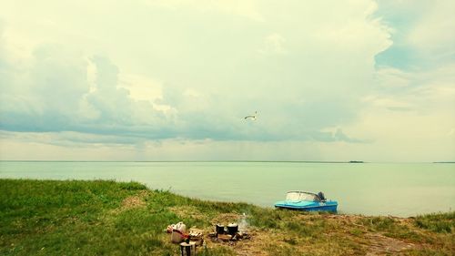 Scenic view of lake and campsite against cloudy sky