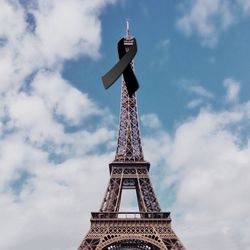 Low angle view of tower against cloudy sky