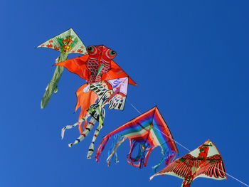 Low angle view of colorful kites against clear sky