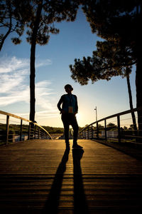 Rear view of silhouette people walking on boardwalk