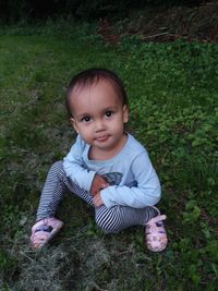 Portrait of cute baby girl on field