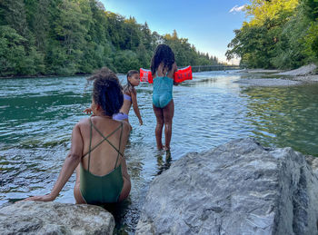 Rear view of woman and girl standing by the river 