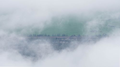 Scenic view of foggy weather against sky