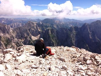 Rear view of male hiker sitting on mountain