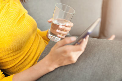 Low section of woman holding drink