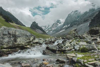 Scenic view of mountains and river against cloudy sky