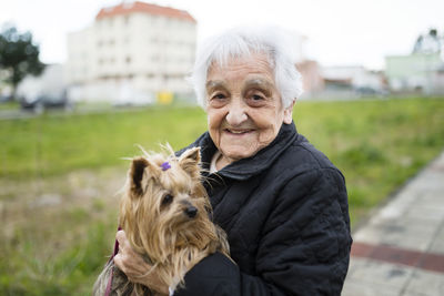 Portrait of senior woman with yorkshire terrier on her arms