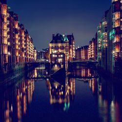 Illuminated buildings in water at night