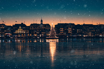 View of hamburg's snowy inner city with its illuminated christmas tree on the alster lake