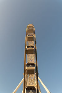 Low angle view of ferris wheel against clear blue sky