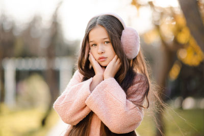 Cute kid girl 10-12 year old with long blonde hair wear fluffy headband earphones and pink jacket 