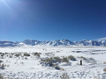 Scenic view of snowcapped mountains against clear blue sky