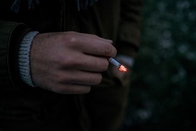 Midsection of man smoking cigarette