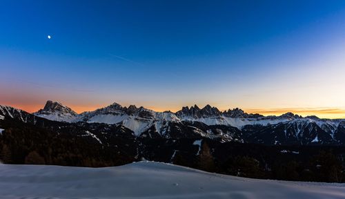 Scenic view of snowcapped mountains against sky during sunset