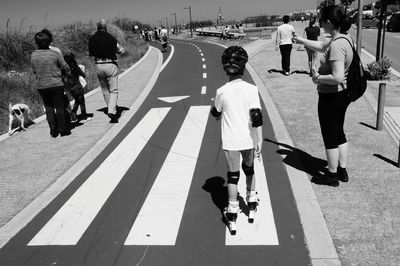 Rear view of people walking on road