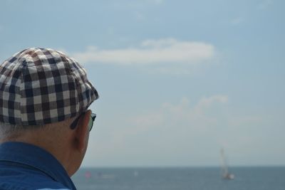 Rear view of man looking at sea against sky