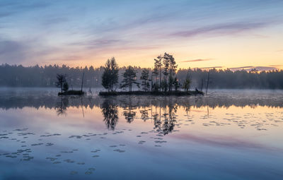 Scenic view of lake against sky at sunset