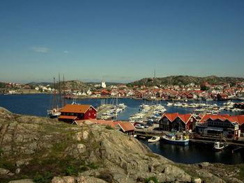 Boats moored in harbor against clear sky