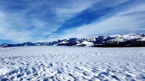 Surface level of snow covered mountains against sky