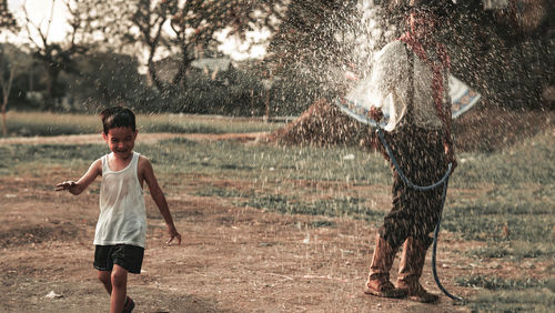 Full length of boy splashing water