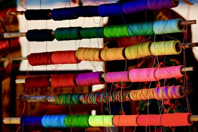 Close-up of colorful spools hanging for sale