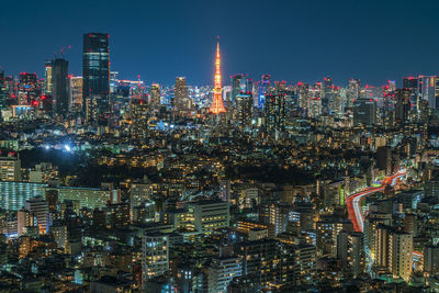 Illuminated cityscape against sky at night