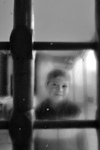 Close-up of girl looking through window