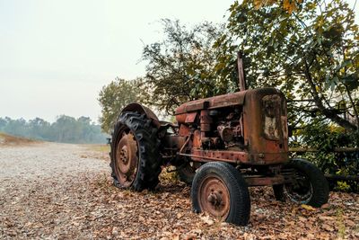 Abandoned tractor on field against sky