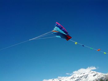 Low angle view of kite against clear blue sky