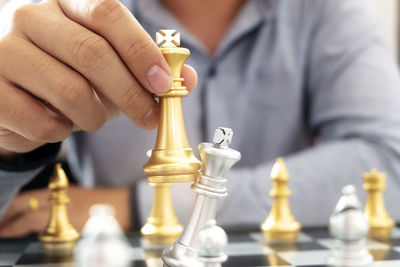 Midsection of man holding chess pieces