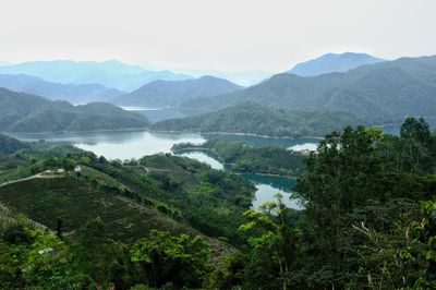 Scenic view of river and mountains against sky